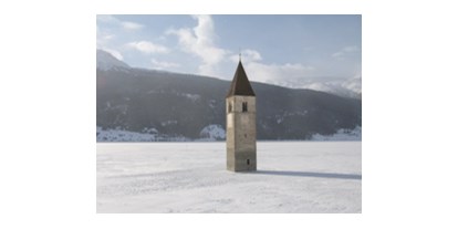 Hundehotel - Unterkunftsart: Hotel - Graun im Vinschgau - Kirchturm im gefrorenen Reschensee - Hotel Reschnerhof