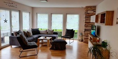 Hundehotel - Unterkunftsart: Appartement - Wohnzimmer mit Terrasse und Garten, Gartenblick  - Monteur- und Ferienwohnung Gästehaus Rhein-Main Ferienwohnung