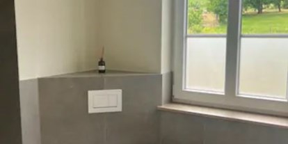 Hundehotel - Garten - Ein modernes Badezimmer mit Dusche, Waschtisch und WC-Anlage komplettiert die Wohnung. - Feriendomizil Im Saarschleifenland  (Camille Ollinger )